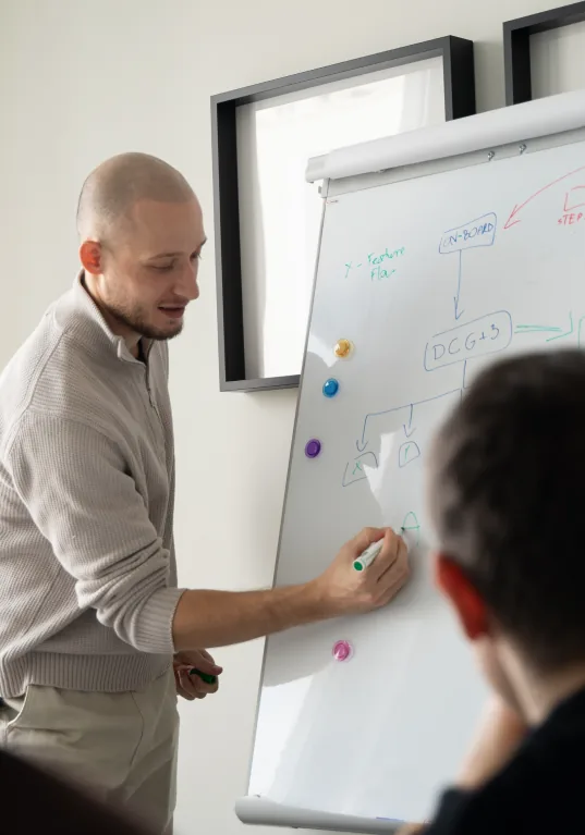 Jakub Wujek prowadzi warsztat, rysując diagram na flipcharcie