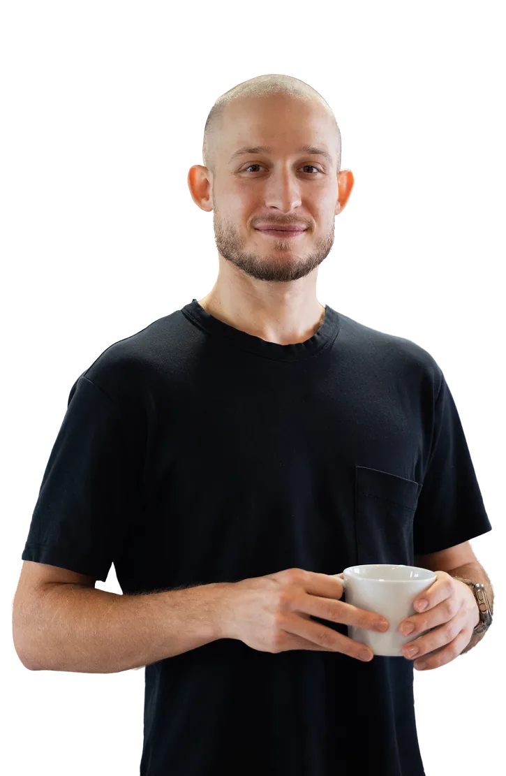 Jakub Wujek — product designer i konsultant, z kubkiem kawy